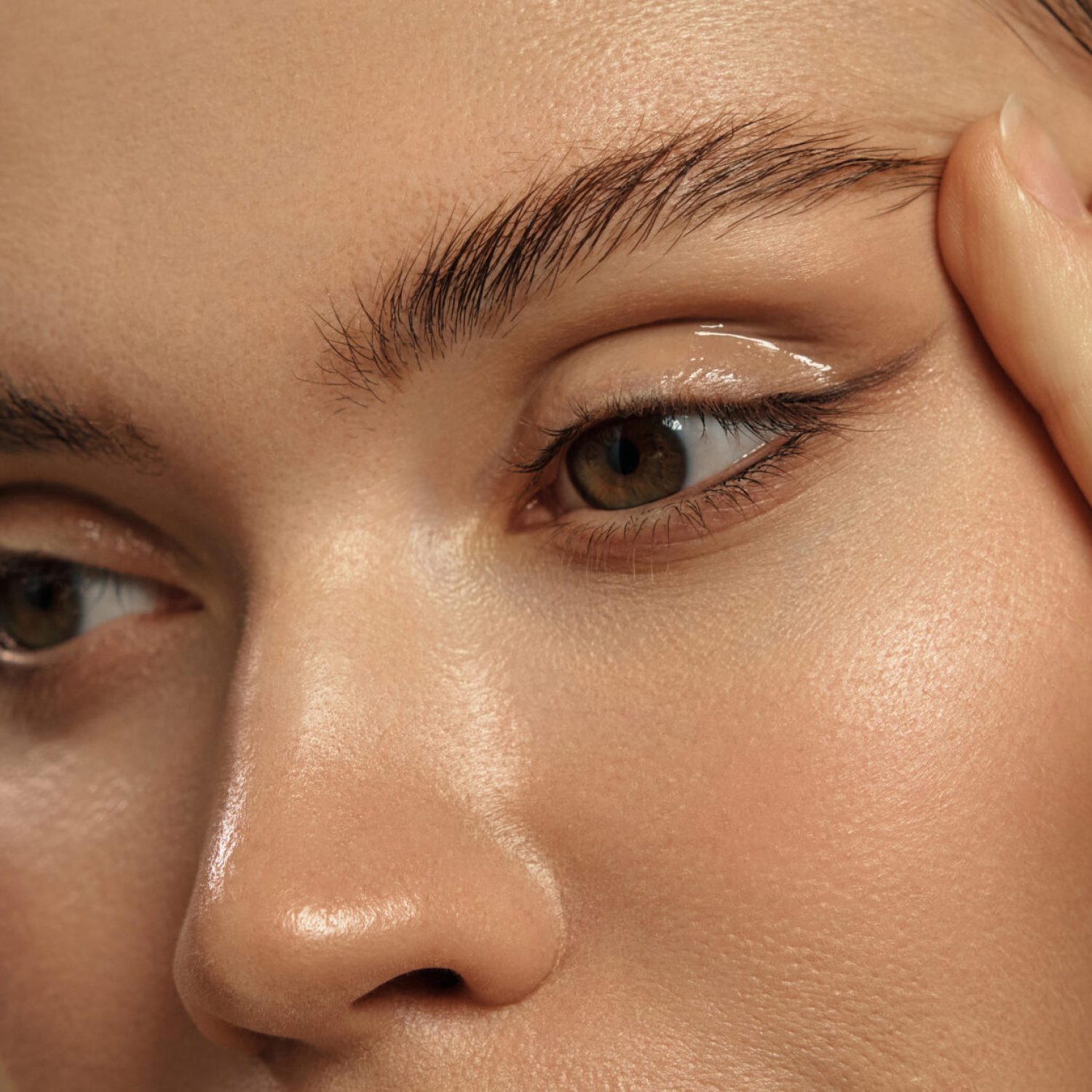 Extreme close-up of a woman's eye with glossy eyeliner and flawless glowing skin. Natural makeup, healthy complexion, skincare and beauty concept. Concept: eye makeup, glow, skincare.